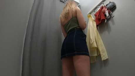 Sexy schoolgirl tries on swimsuits in the locker room of the store.